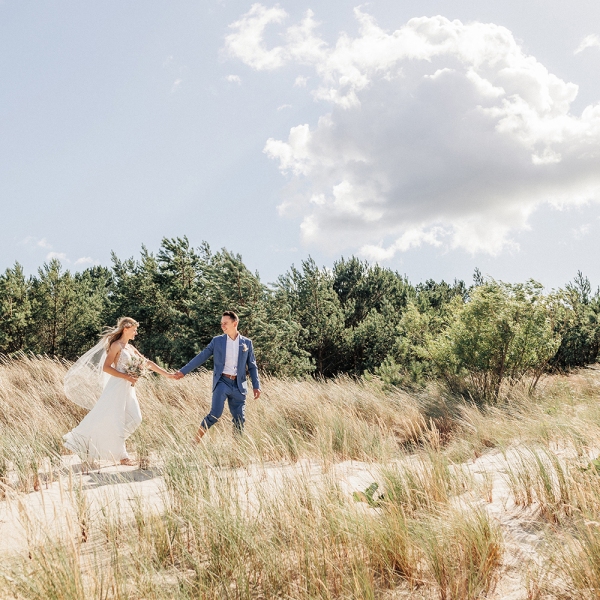 Brautpaar läuft durch die Dünen von Usedom